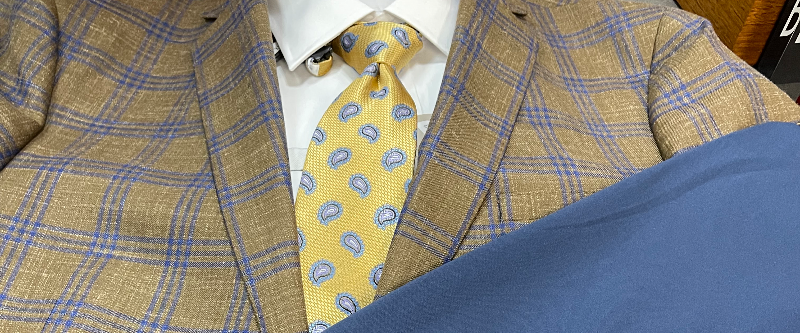 Plaid sports coat paired with a yellow paisley tie